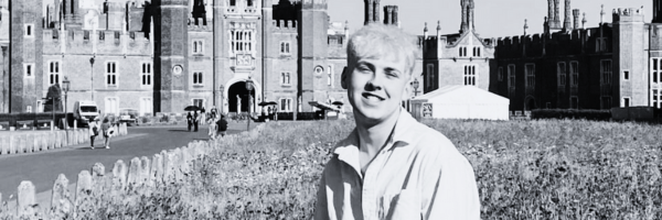 Aaron stands outside a palace, stylised in black and white.